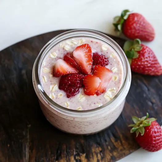 A bowl of yogurt with strawberries on top.