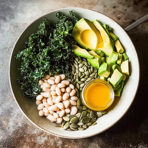 A colorful salad bowl featuring beans, kale, and avocado.