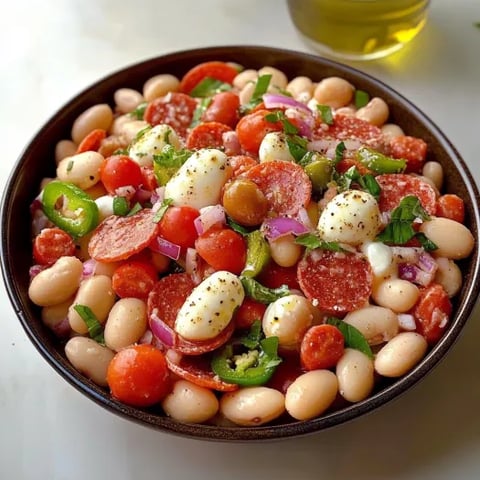 A bowl of mixed beans, tomatoes, cheese, and peppers.