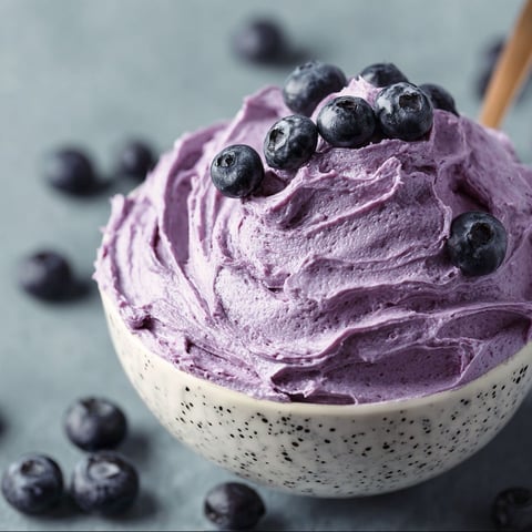 A bowl of blueberry cream cheese frosting.
